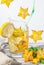 Star fruit falls with a splash. In a refreshing cocktail with citrus and mint in a glass. White background. Close-up