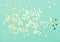 Star shaped golden confetti mint color flat lay background