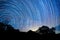 Star trail over Colima volcano silhouette