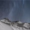 Star trails, snow capped mountains