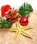 Starfish, christmas ball, christmas hat and pine twig on the sand