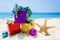 Starfish with Christmas balls and gift on the beach - holiday co