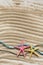 Starfish and colored ropes on a background of wavy sand. Marine cruise theme. Top view with place for text