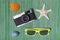 Starfish, retro camera, sunglasses, sea snail and sea shell on bamboo straw mat