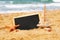 Starfish, sailboat and chalkboard, on sea sand and ocean horizon