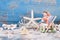 Starfish and shells with figurine in deck chair for summer, holiday, travel concepts