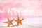 Starfish on white sand with festive glitter background