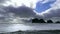 Stark contrast of sea stacks near the beach with blue sky