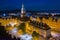 Starry evening over Jelenia Gora market square. Beautiful illuminated town hall building, old tenement houses and restaurants