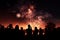 Starry explosions People watch in silhouette as fireworks light up