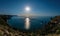 Starry night with a full moon over sea, yachts and rocks in front. Cape Fiolent, Orest and Pilad rocks on the background of the