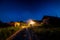 Starry night sky over village house in summer. Wooden house with one bulb light over entrance. Russia