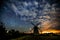 Starry sky above an old wooden windmill