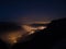 Starry sky and high mountain range, Italian French Alps, mist and fog in the vally with glowing villages below.