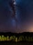 Starry sky and Milky Way arc, with details of its bright colorful core, captured from green oasis in the Namib desert, Namibia, Af