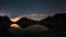 Starry sky and Orion Time Lapse on the Alps, beyond snowcapped mountain ridge, reflection on idyllic alpine lake