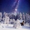 Starry sky and a tree in frost at the beautiful house in the woods in midwinter.