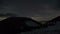 Stars and clouds moving in night sky over winter mountains. Dreamy astronomy time lapse