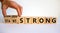 Start and finish strong symbol. Businessman turns wooden cubes, changes words `start strong` to `finish strong`. Beautiful whi