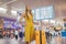 Start of her journey. Beautiful young woman ltraveler in a yellow dress and a yellow suitcase is waiting for her flight