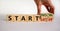 Start now or later symbol. Businessman turns wooden cubes and changes words `start later` to `start now`. Beautiful white