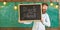 Start of school year concept. Teacher on cheerful face holds blackboard with title back to school. Man with beard