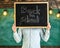 Start of school year concept. Teacher faceless holds blackboard with title back to school. Man welcomes students