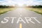 Start word writen on asphalt road with natural background