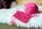 Started knitting with pink thread on a cozy sheepskin