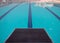 Starting blocks in row by the swimming pool, selective focus. Jump platform for swimming in swimming pool and grandstand backgroun