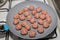 Starting the cooking of raw meatballs on a pan over the stove