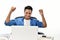 Startup business man raising his hands feeling happy for achieving work while using laptop