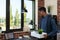 Startup employee getting fired holding tray with personal belongings giving a last look at his desk