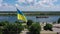 State flag of Ukraine above Dnieper river and Ukrainian lands, slow motion effect. Symbol of independent Ukraine