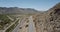 Static aerial shot of majestic desert rock hills road in Arizona, drone rising when car passes by. Road trip concept.