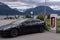 A static shot of a solid black Tesla Model 3 dual motor charging at the Skibotn Supercharger