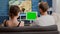 Static tripod shot of man and woman couple watching influencer vlog using digital tablet with green screen