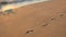Static very wide shot of footprints in the sand on waimanalo beach hawaii