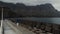 Static view from the drone on a young girl standing on a pier on a dark day. Agaete, Gran Canaria, Spain