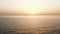 Static wide aerial background shot of rippled ocean waves and sun going down, amazing orange sunset mood panorama.