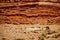 Station wagon automobile on road up mountain entering Arches National Park near Moab Utah with geology of layered cliffs behind it