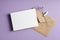 Stationary greeting card mockup with envelope and dry flower twig on lavender color background