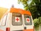 Stationary white ambulance car with red cross on the windows on a sunny summer day. An emergency medical service van. Rear view