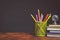 Stationery metal glass with pencils next to books with copy space