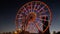 Statue of Ali and Nino on a background Ferris wheel at night on the embankment of Batumi, Georgia