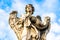 Statue of an Angel with the Garment and Dice by Paolo Naldini on Sant'Angelo brigde in Rome, Italy