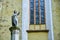 Statue of Bishop Georg Paul Binder next to a window with round glass pattern, near the entrance in Biertan fortified church.