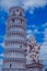 Statue of cherubim on the background of the leaning tower