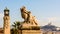 A statue of child and lion in Marseille, France, with Notre-Dame de la Garde basilica in the distance