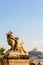 A statue of child and lion in Marseille, France, with Notre-Dame de la Garde basilica in the distance